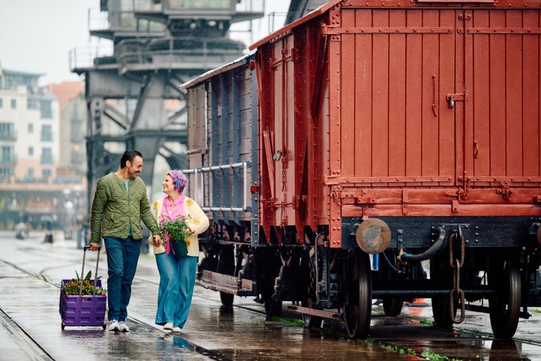 A man and woman walking next to a train