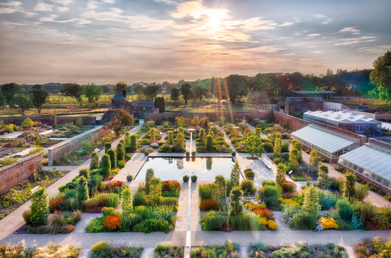 A garden with a fountain and a building