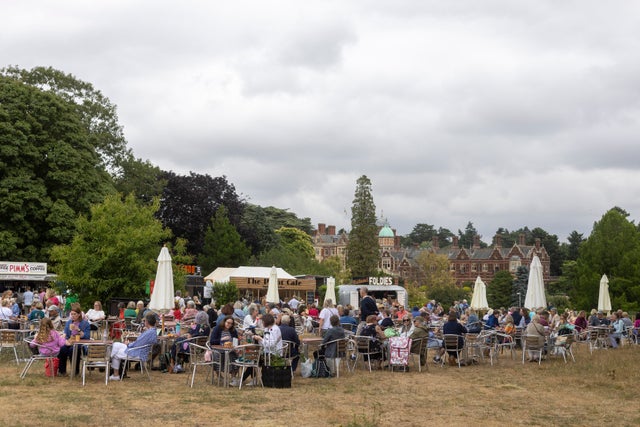 A group of people sitting at tables outside