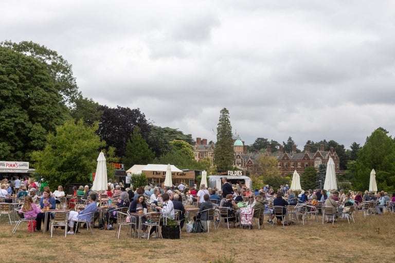 A group of people sitting at tables outside