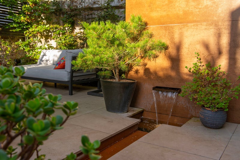 A stepover rill fed by an wall-mounted water feature