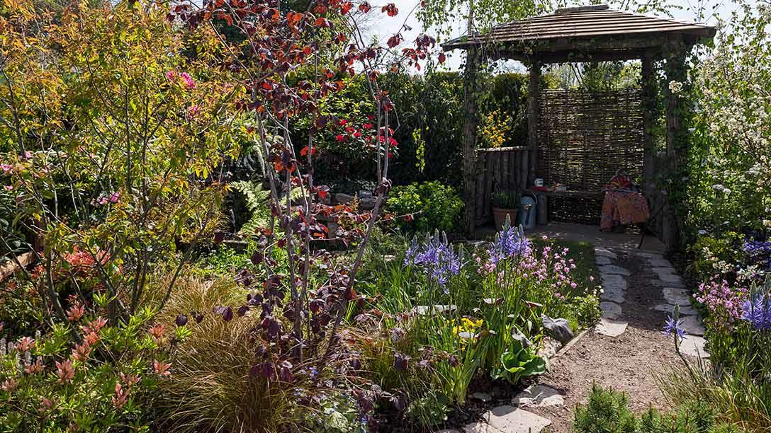 A garden with a gazebo and flowers
