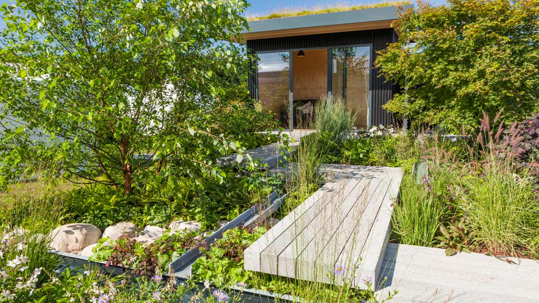 A garden with a walkway and a building