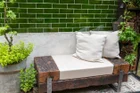 Thumbnail: A bench with pillows and plants in front of a wall