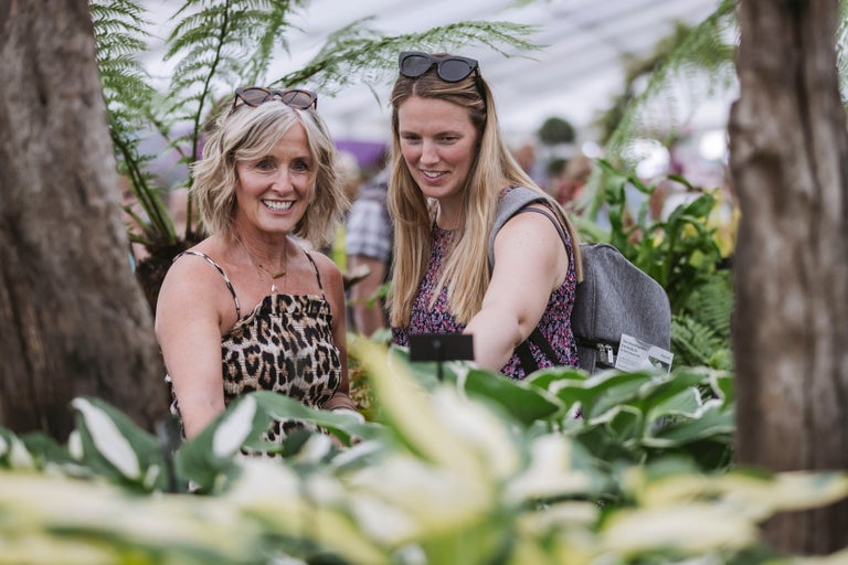 Two women standing in a garden