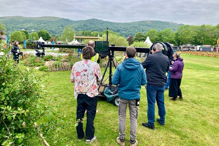 A group of people standing in a field for filming