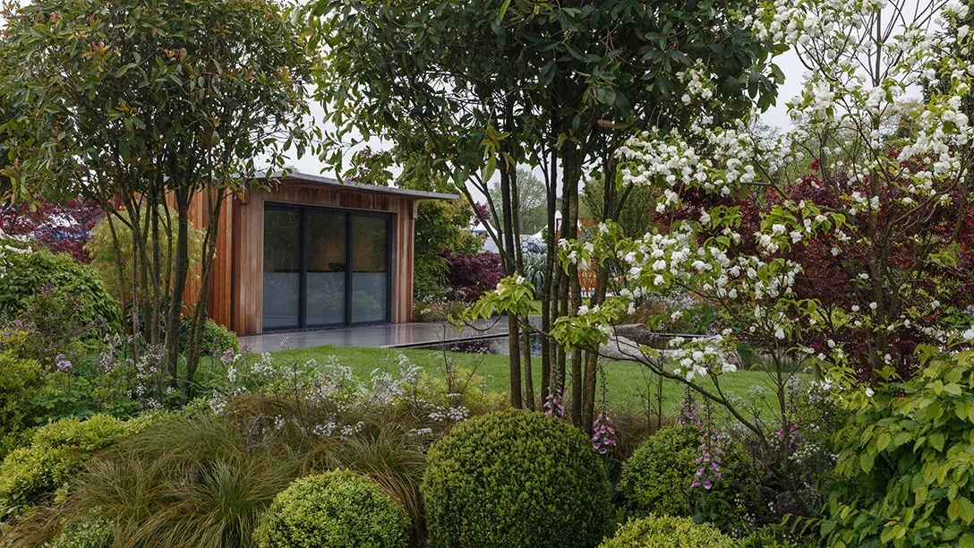 A garden with a building and trees