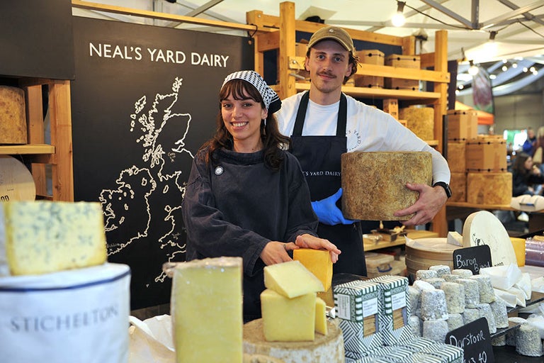 A man and woman holding cheese