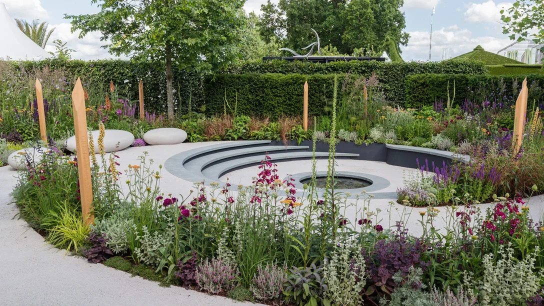 A garden with a circular walkway and a circular fountain