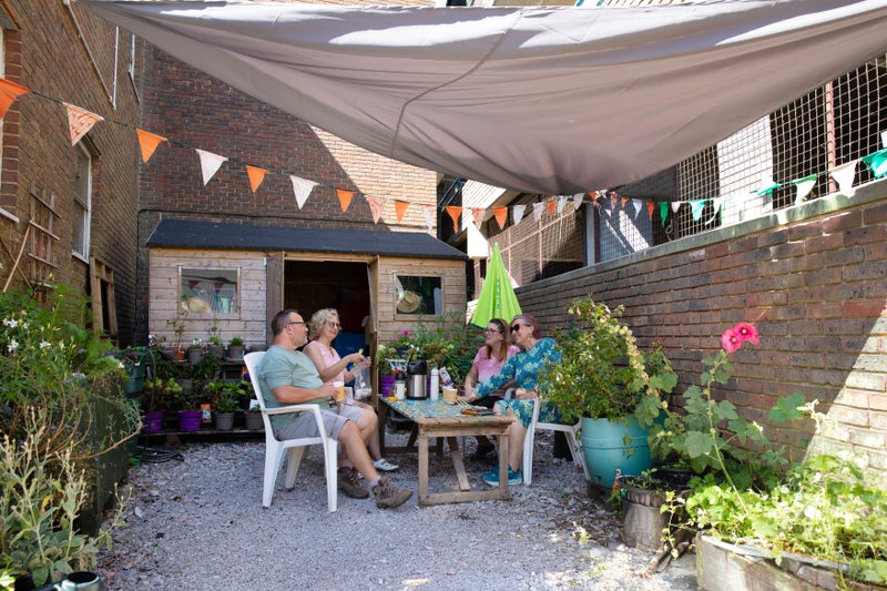 A group of people sitting outside under a canopy