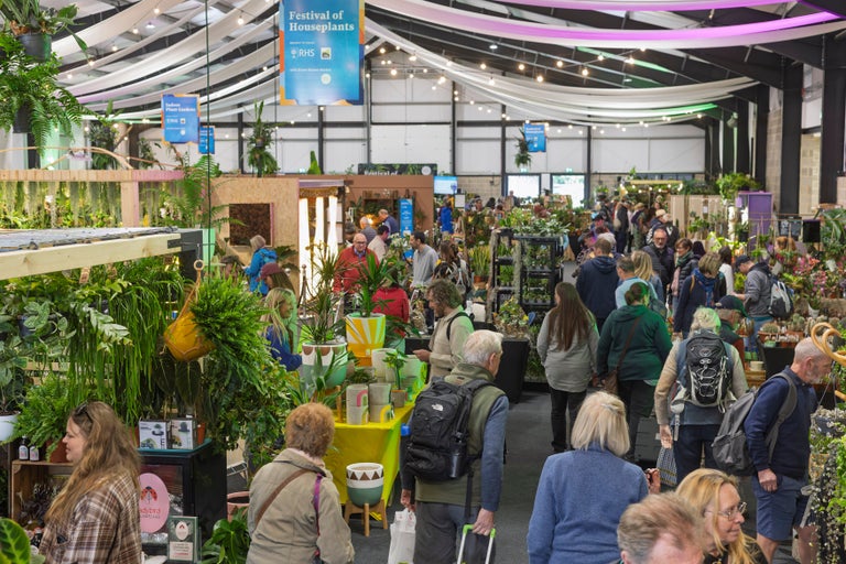 A group of people in a large room with plants
