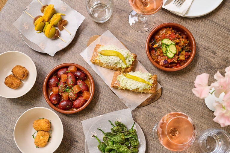 A table with plates of food and glasses of wine