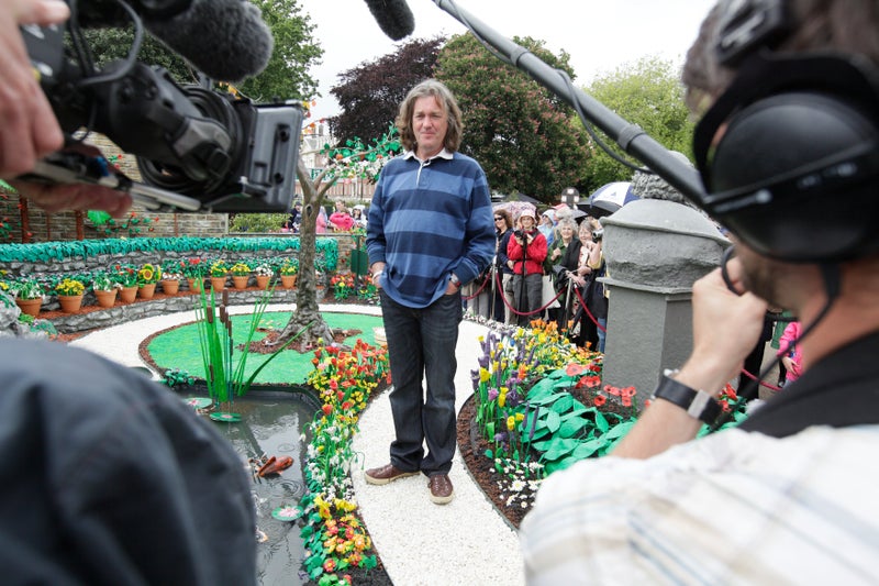 A man standing in a garden with a group of people