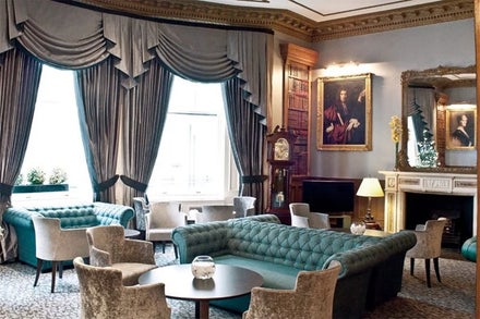 A room with a couch and chairs