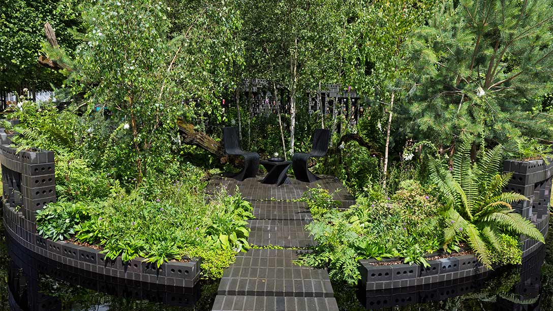 A walkway in a garden with chairs and plants